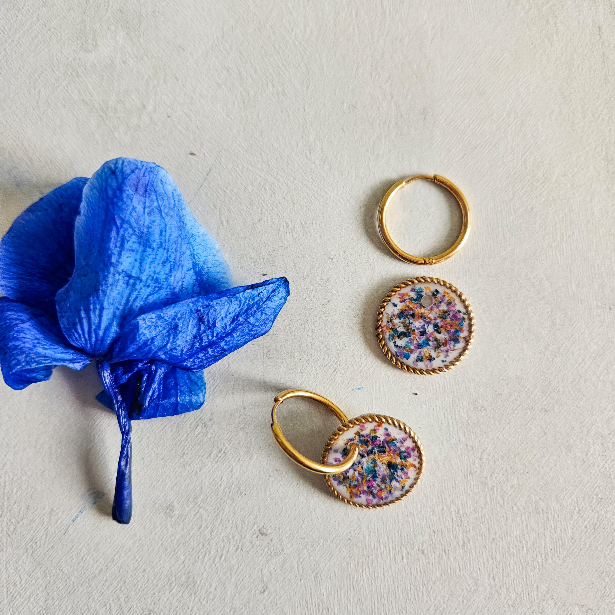 Orecchini a cerchio con ciondolo circolare ondulato con fondo bianco e mix di fiori viola e blu